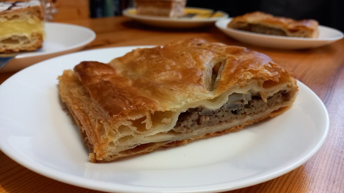 Flaky golden steak pie on a plate
